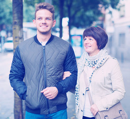 Mature woman and guy taking walk