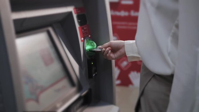 young woman inserting a credit card to ATM, beautiful girl banking