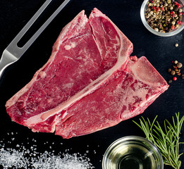 Raw beef steak on a dark background.