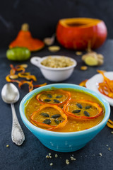 Tasty pumpkin soup in bowl on stone background.
Vegetarian food.