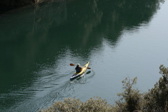 Junge mutige und sportliche Frau paddelt alleine auf dem Grand Canyon in der Provence/Südfrankreich in tiefem Fluss