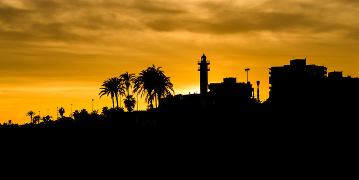 silueta de edificios y del faro