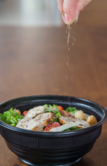 Organic mixed green salad with chicken in a transparent plastic plates on  wooden table very tasty
