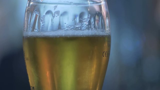 Close up of beer glass with blur background stock footage.