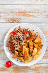 fried potato and portion of pulled slow-cooked meat