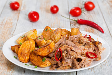 pulled slow-cooked pork shoulder with fried potato wedges