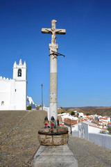Fototapeta na wymiar MERTOLA, PORTUGAL: The Matriz Church (former Mosque of Mertola) with a religious cross in the foreground