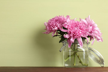 Vase with beautiful flowers are on the table.