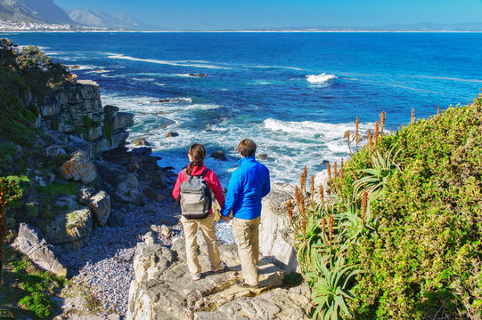 Happy couple looking at beautiful ocean view in Hermanus, romantic vacation in South Africa
