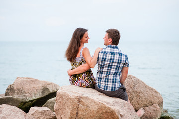 Young couple on the rocks in the sea