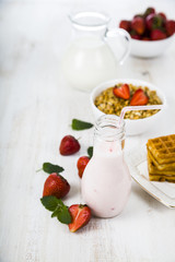 Smoothies and ripe strawberry on a wooden table. Milk drink with