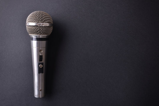 Silver metal microphone on black table top view