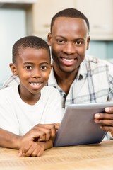 Naklejka premium Father and son using tablet together