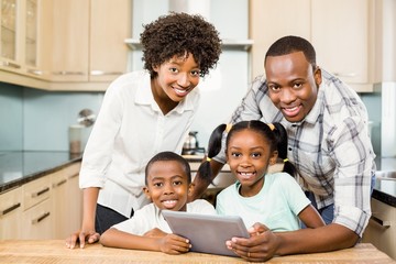 Happy family using tablet in kitchen