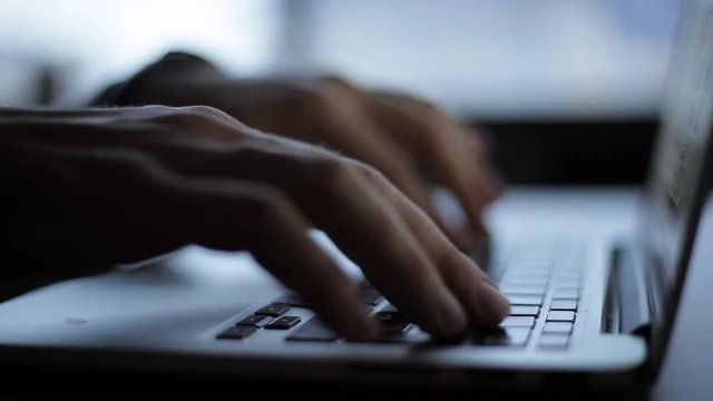 Hands touch typing on a laptop keyboard