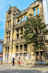 Obraz premium Two girls talking in frot of an abandoned tall building in Jakar