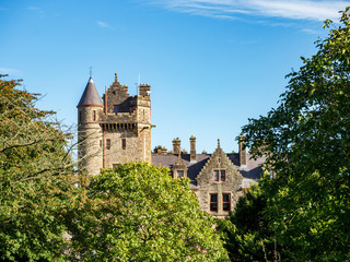 Fototapeta na wymiar Belfast castle among trees. Tourist attraction on the slopes of Cavehill Country Park in Belfast, Northern Ireland