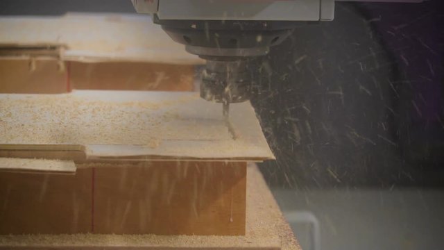 Cutting of a wooden sheet using the CNC machine following a pattern to create the piece