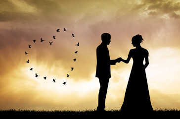 Obraz premium bride and groom silhouette at sunset