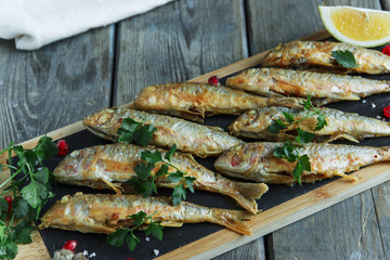 fried fish goatfish surmullet with lemon on board