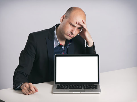 angry bald businessman with laptop