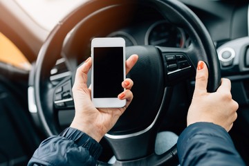 Woman using white smartphone in car.