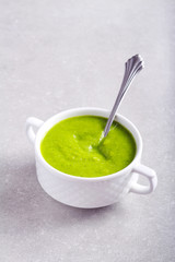 Broccoli soup in a bowl over grey background