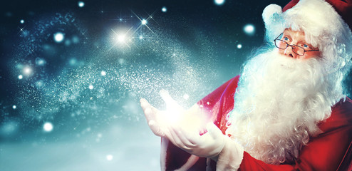 Portrait of happy Santa Claus with magic light in his hands 