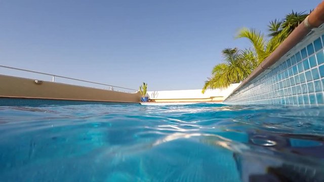 inside swimming pool - water, waves and blue sky slow motion