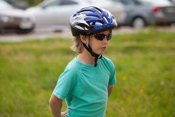 Cute kid with sunglasses and protect helmet outdoor 

