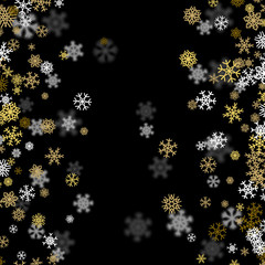 Snowfall background with golden snowflakes blurred in the dark