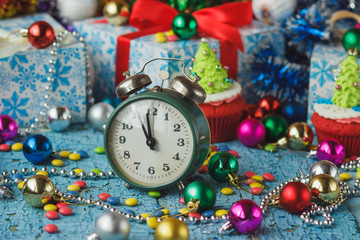 Fototapeta na wymiar Christmas clock and cupcakes with colored decorations