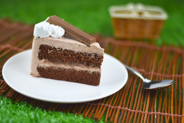 chocolate cake with whip cream and chocolate wafer topping on gr