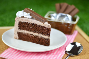 chocolate cake with whip cream and chocolate wafer topping on gr