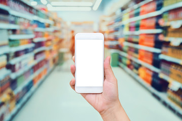 Female hand holding mobile phone with Supermarket background