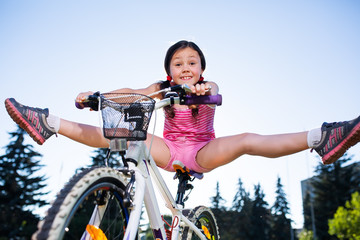 happy child girl riding bicycle in summer sunset