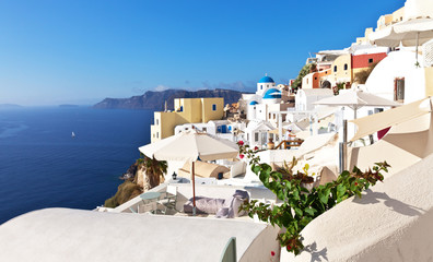 Fototapeta premium White rounded roofs in the traditional Cycladic houses in the picturesque Oia village, Santorini, Greece