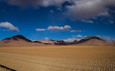 Fototapeta na wymiar Desert and mountain over blue sky and white clouds on Altiplano,Bolivia Chile