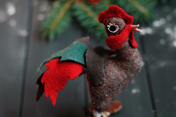New Year 2017 symbol - handmade rooster with fir branches and cranberry on gray wooden background