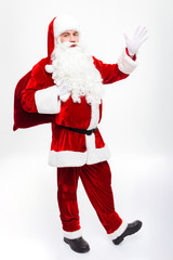 Happy man santa claus standing and holding gift sack