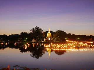 Obraz premium light in Buddha Statue at Temple in Loy Kratong Festival at twilight time, Sukhothai Historical park , Thailand