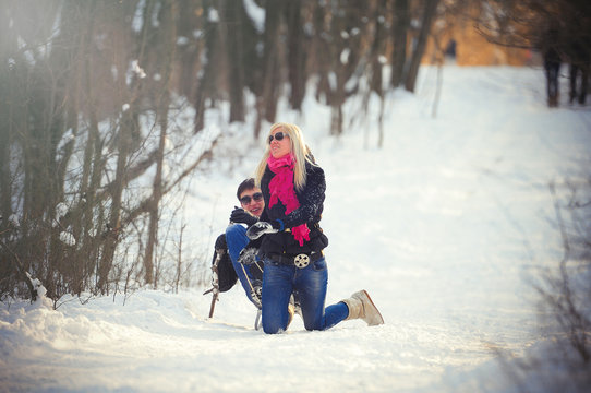 young man and woman on a sled