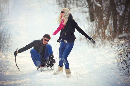 young man and woman on a sled