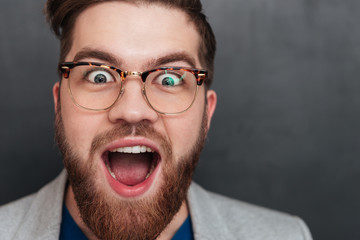Surprised happy young businessman in glasses with opened mouth