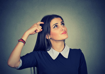 Confused thinking woman bewildered scratching head seeks a solution
