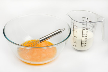 Mixed whisked eggs with wire isolated over white