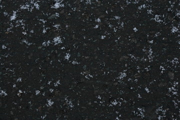 Obraz premium 黒く凍ったアスファルトに落ちた雪