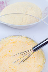 Mixed whisked eggs with wire isolated over white
