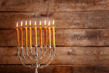Menorah with candles for Hanukkah on wooden background