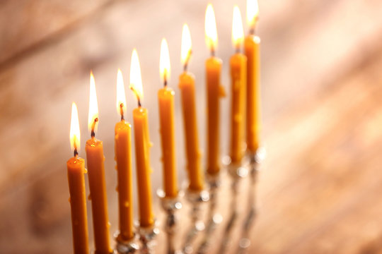 Menorah with candles for Hanukkah on blurred wooden background, close up